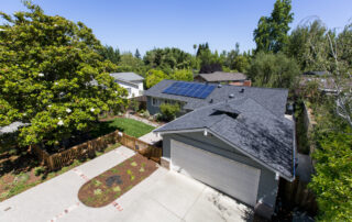 Skyview photo of a home showing solar panels installed on top of a roof.