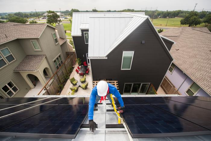 An Evergreen Solar specialist is installing solar on a rooftop.