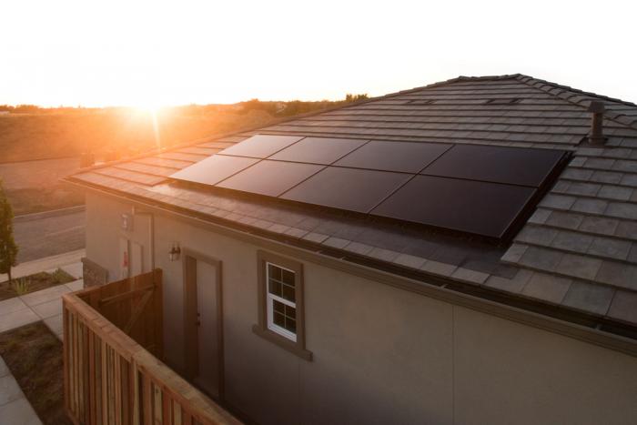 Evergreen Residential Solar array on a house rooftop during a sunset or sunrise