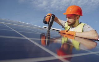Photo shows a solar installer working on a solar panel