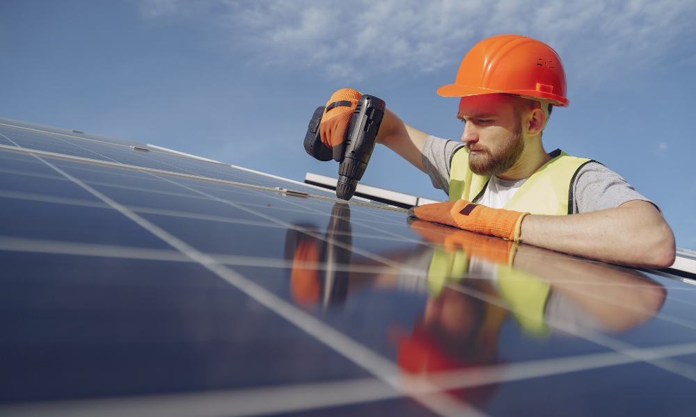 Photo shows a solar installer working on a solar panel