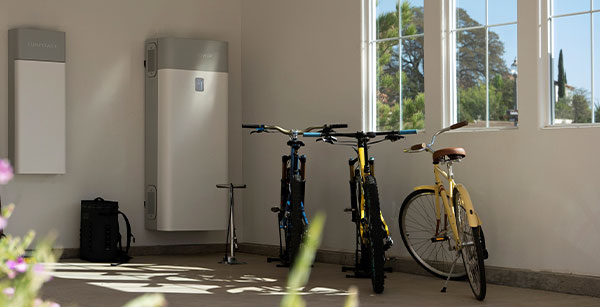 Solar battery storage in a garage with 3 bikes being stored.