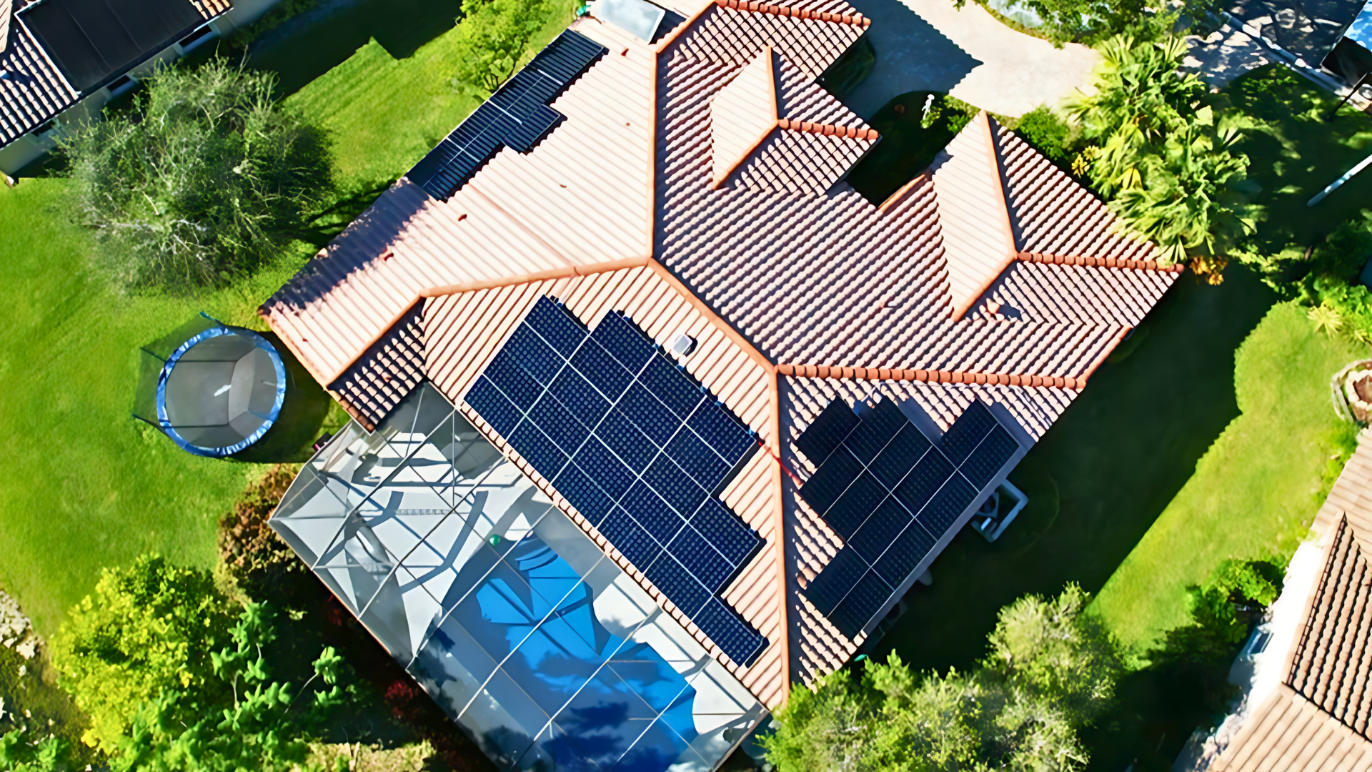 Aerial view of a home in Florida with solar panels installed on the roof, showcasing a solar energy and battery storage system integrated into a residential property with a trampoline and well-maintained yard.